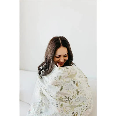 A woman smiles while wrapped in a lightweight, patterned canopy suitable for a baby car seat.