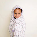 Big kid wearing a Disney Minnie Mouse-themed hooded towel with floral and butterfly patterns, smiling at the camera.