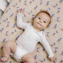 Premium crib sheet featuring Mickey Mouse print with a baby in a light onesie lying on it.