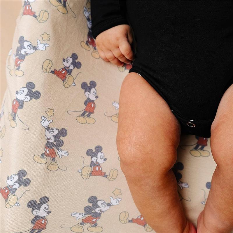 Premium diaper changing pad cover featuring a playful Mickey Mouse pattern, with a baby’s legs and hands visible.