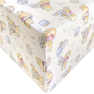 Premium crib sheet featuring playful Winnie the Pooh illustrations and pastel honey pots.