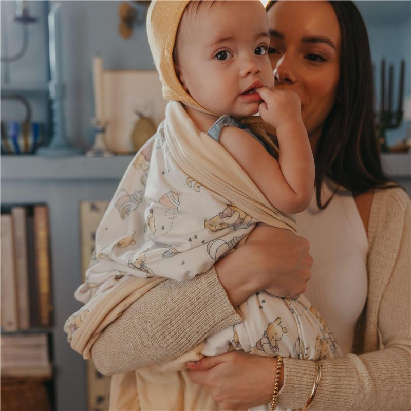 A woman holds a baby wrapped in a Copper Pearl large premium knit baby blanket with a Hunny bear design.