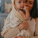 Baby wrapped in a Copper Pearl large premium knit quilt blanket with a Hunny print, held by a smiling woman.