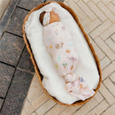 Large premium knit baby swaddle blanket by Copper Pearl features whimsical designs, wrapping a peacefully sleeping infant in a cozy basket.