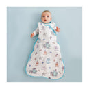 Baby wearing a Copper Pearl Monsters Inc Friends 0.5 Tog Sleep Bag, featuring colorful monster illustrations, on a light blue background.