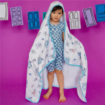 Big kid wearing a Monsters Inc. themed hooded towel with cartoon characters, standing on a purple background.