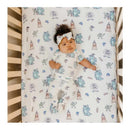 Premium crib sheet featuring Monsters Inc. characters, with a baby wearing a matching outfit and headband in a crib.