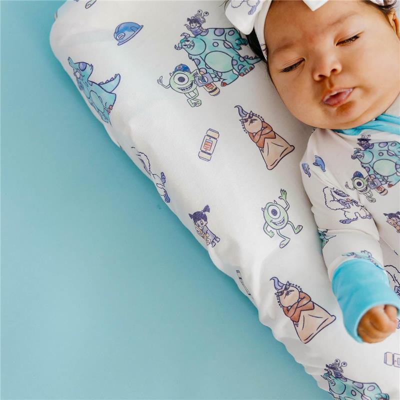 Premium diaper changing pad cover featuring colorful Monsters, Inc. characters, with a sleeping baby in a blue onesie.