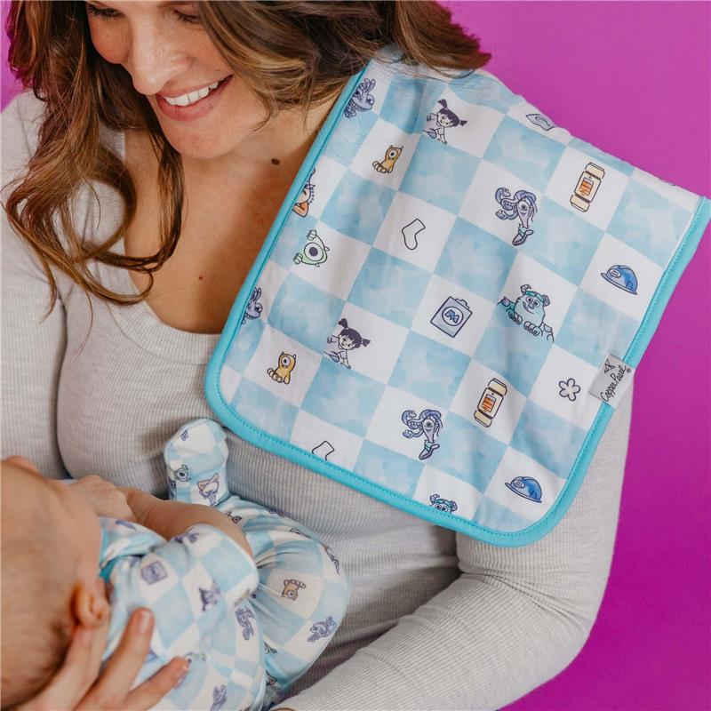 Burp cloth with a blue checkered pattern featuring characters from Monsters Inc., held by a smiling woman with a baby.