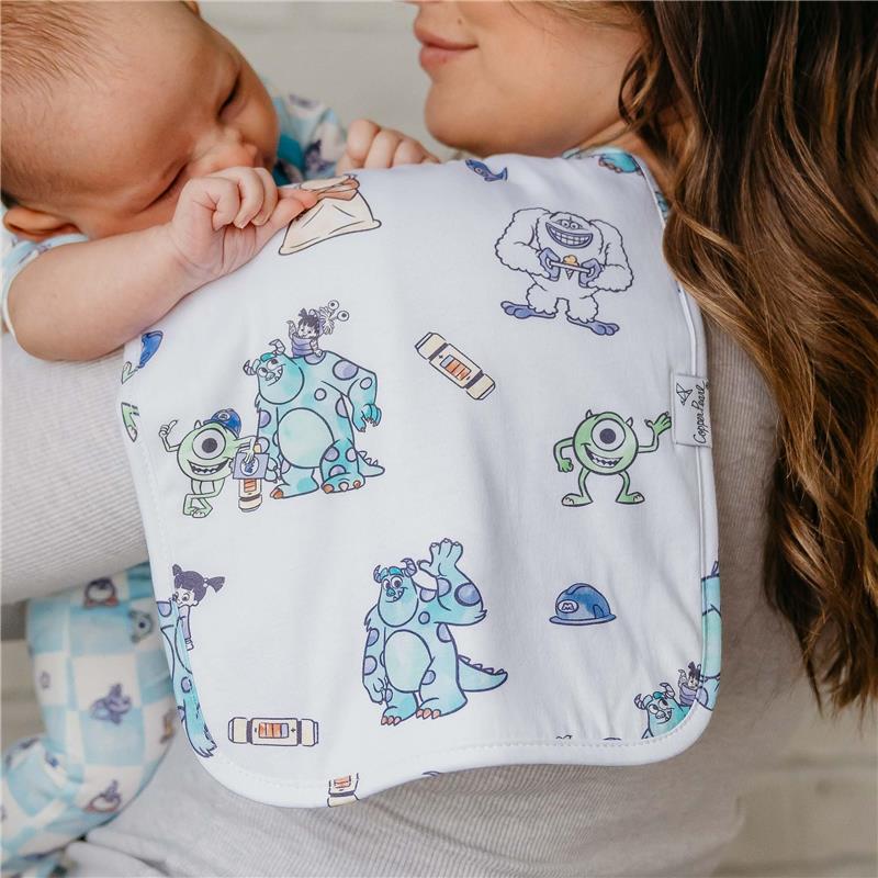 Burp cloth featuring characters from Monsters Inc., being used by a woman holding a baby.