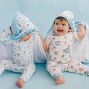 Two babies in hooded towels featuring Monsters Inc designs, sitting on a blue background, smiling and playing.