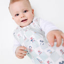 A happy baby wearing a Copper Pearl 3-layer knit sleep bag featuring Mickey Mouse and friends, reaching out with one hand.