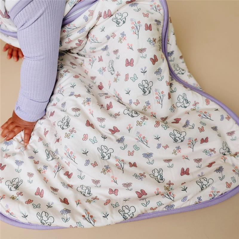 Copper Pearl 1.0 TOG sleep bag featuring a floral and butterfly design, modeled by a child sitting on a neutral background.