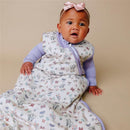 Baby wearing a Copper Pearl 3-layer knit sleep bag, featuring floral and butterfly patterns, with a pink bow headband.