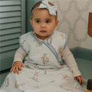 Infant wearing a Copper Pearl 3-layer knit sleep bag with Winnie the Pooh characters, sitting on a patterned rug.