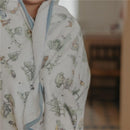 Premium hooded towel featuring Hundred Acre Wood designs, wrapped around a child, showcasing its softness and whimsical illustrations.