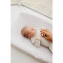 Premium knit diaper changing pad cover in Twinkle pattern with a sleeping baby and a gentle hand holding its hand.