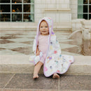 Hooded bath towel featuring Disney Princess designs, wrapped around a smiling baby sitting by a fountain.
