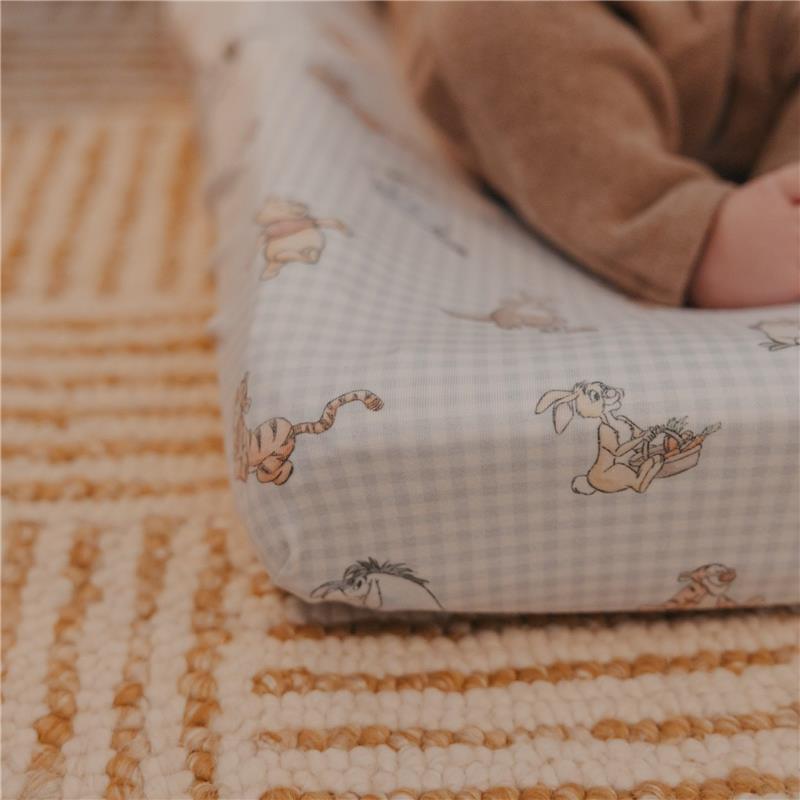 Premium diaper changing pad cover featuring Winnie the Pooh characters on a light checkered background.