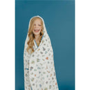 Big kid wearing a whimsical hooded towel featuring various magical designs, smiling against a blue background.