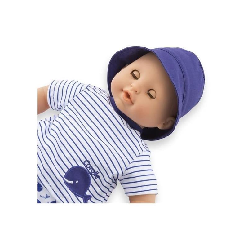 Corolle Bebe Bath Marin Baby Doll wearing a striped shirt and purple hat, featuring a soft body and rubber whale toy.