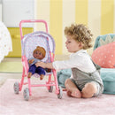 Child playing with a pink floral pushchair, holding a 30 cm doll dressed in a striped outfit and brown hat.