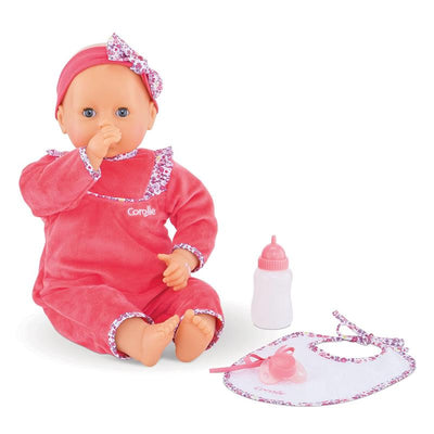 Corolle Mon Grand Poupon Purple Chérie doll in a pink outfit, sucking her thumb, with a bottle and bib beside her.