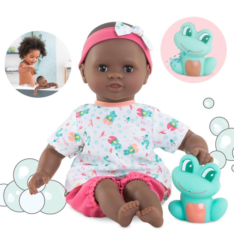 Corolle Mon Premier Poupon Bath Baby Alyzee with dark skin, wearing a patterned shirt and pink shorts, holding a green frog toy.