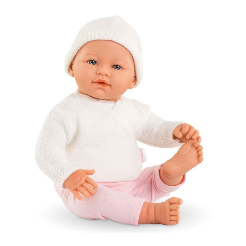 17-inch Corolle doll wearing a white knit sweater and pink pants, seated with a beanie on its head, showcasing realistic features.