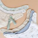 Three muslin bibs in soft pastel colors, with two utensil pieces; designed for feeding infants, featuring snap buttons.