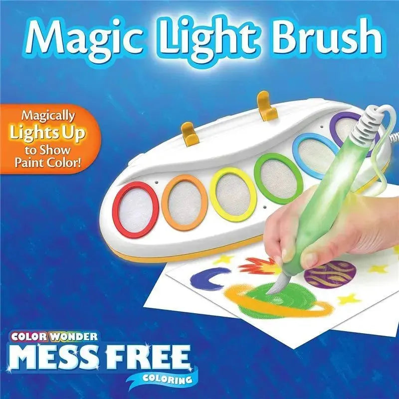 Crayola Color Wonder Magic Light Brush with a hand holding a light-up brush, coloring a space-themed picture on paper.