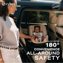 Cybex Aton G2 Swivel infant car seat in stormy blue, featuring a baby secured in the seat, with a woman reaching to adjust it.