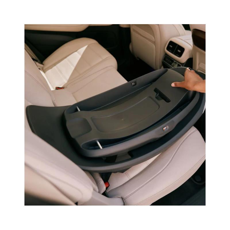 Cybex Aton G2 Swivel Load Leg Base shown being placed on a beige car seat, highlighting its design and functionality.