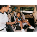 Cybex Callisto G 360 rotating car seat in black, with a child seated calmly, while a woman adjusts the harness.