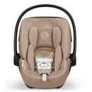 Cybex Cloud G Pro Comfort Extend Infant Car Seat in Almond Beige with a safety harness and a cushioned design.