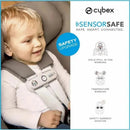 Infant in a Cybex Cloud T car seat with SensorSafe technology, showing features including safety warnings and a happy expression.