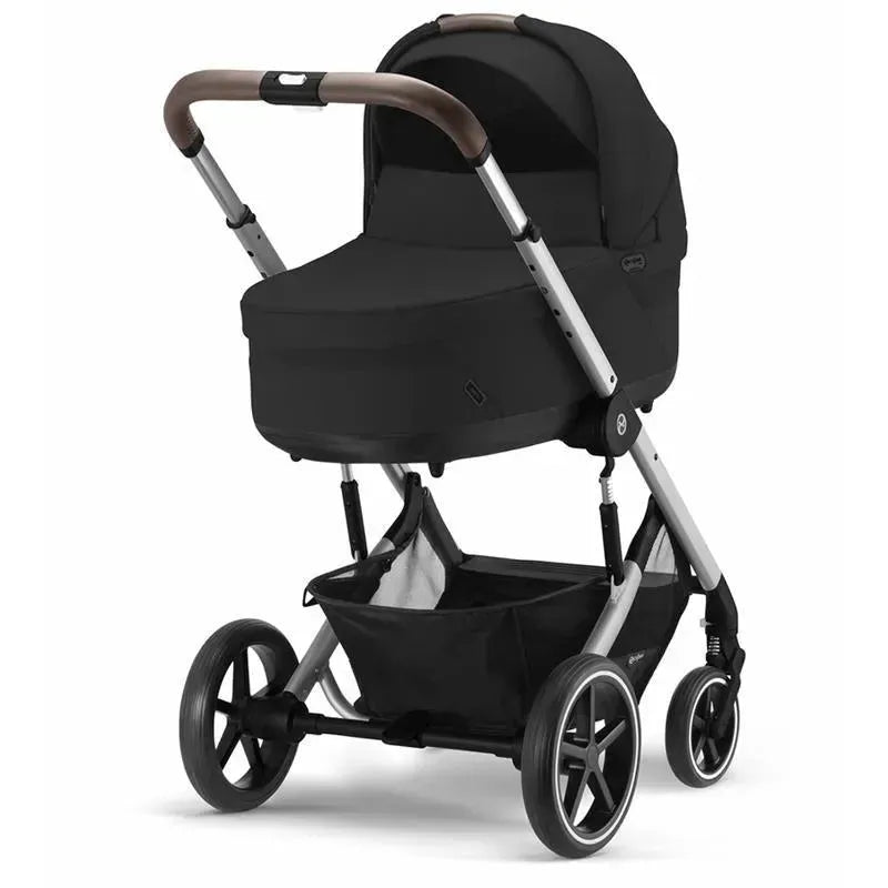 Cybex Cot S Lux 2 in Moon Black, featuring a sleek design, a comfortable bassinet, and sturdy wheel structure.