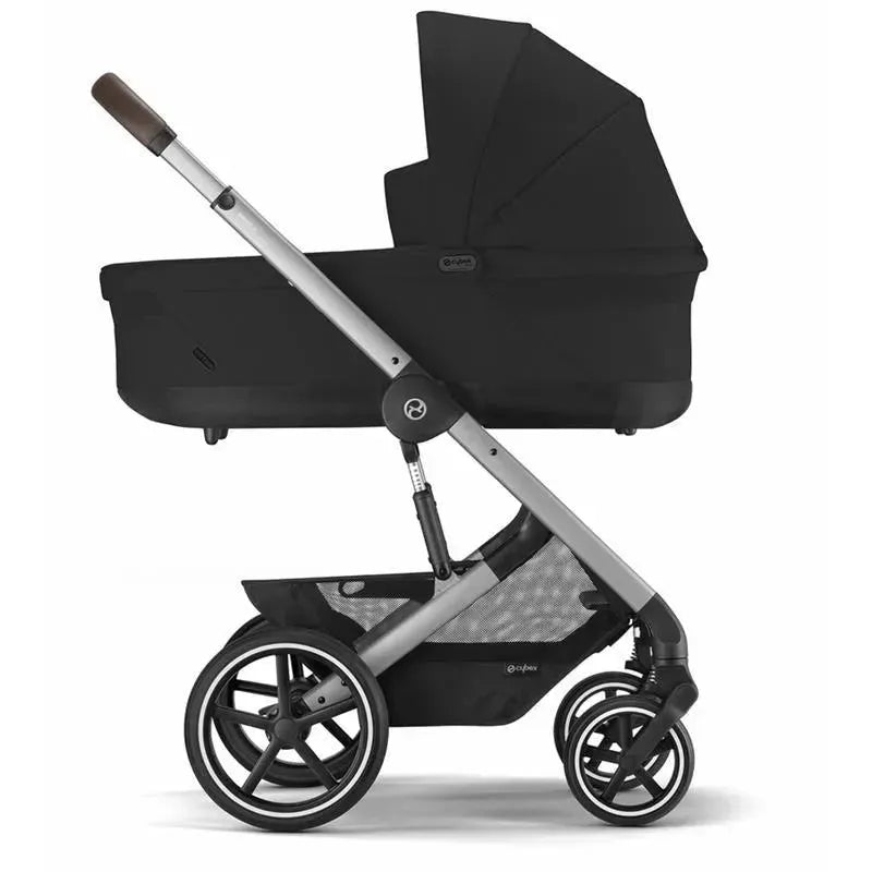 Cybex Cot S Lux 2 in Moon Black with a sturdy silver frame and large wheels, designed for infants with a folding canopy.