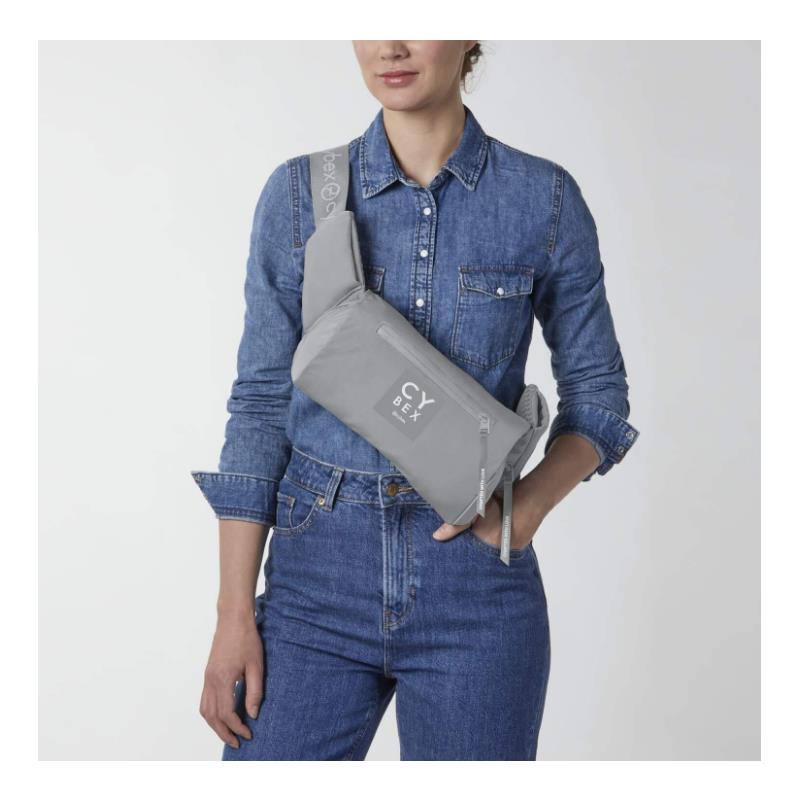 Cybex Coya Carrier in Thunder Grey worn by a model, featuring a sleek design and adjustable strap.