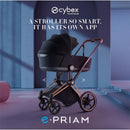 Cybex E-Priam stroller in matte black with a coconut brown lux seat, displayed in a modern interior.