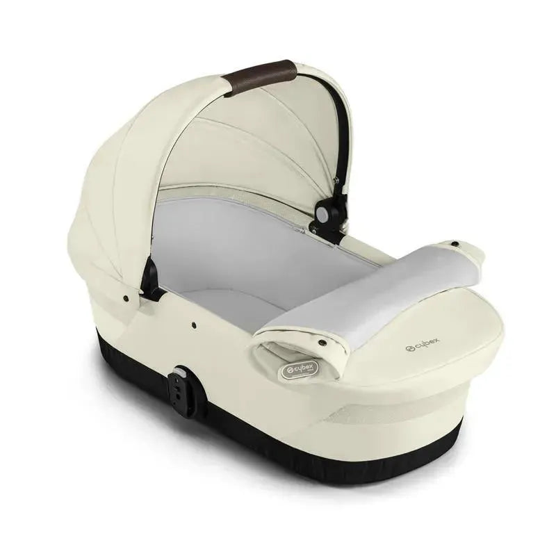 Cybex Gazelle S Cot in Seashell Beige featuring a soft, curved design with a secure interior and removable fabric cover.