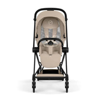 Cybex Mios Stroller with a matte black frame and cozy beige seat, featuring a harness and adjustable backrest.