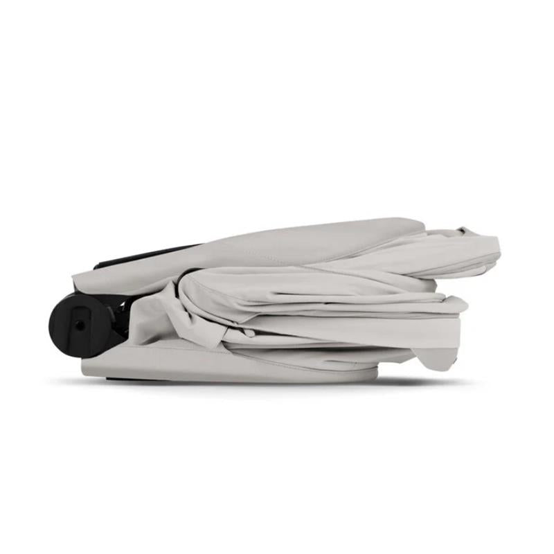 CYBEX PRIAM Fold Lux Carry Cot in City Grey, shown in a folded position with a sleek design and fabric detailing.