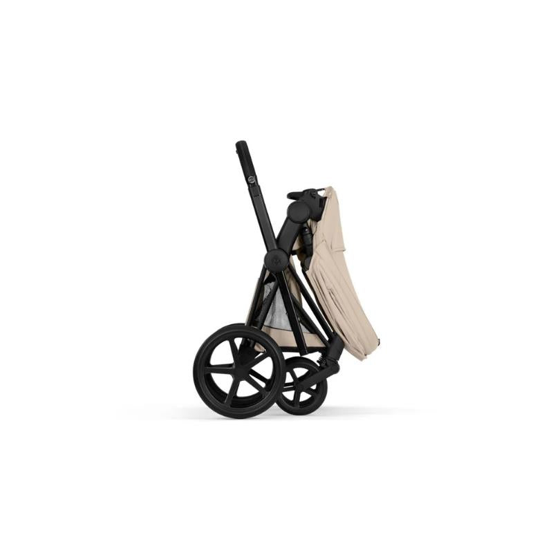 Cybex Priam Stroller with a matte black frame and cozy beige lux seat, displayed in a folded position.