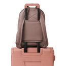 Dagne Dover Dakota Backpack in Dune, large size, featuring a sleek design and straps resting on a handled suitcase.