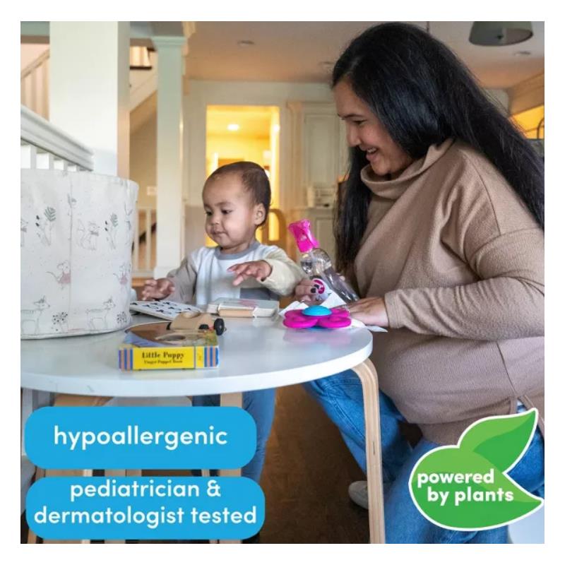 Dapple All Purpose Cleaner Spray on a table near a mother and child, with toys and a storage bin in a bright room.