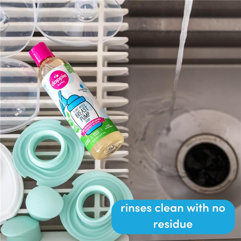 Dapple baby breast pump soap bottle on a drying rack with teal accessories and water flowing in a sink.