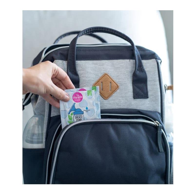 Dapple breast pump wipes package being inserted into a black and gray backpack pocket.