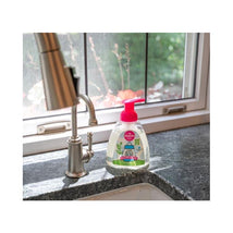 Dapple Foaming Dish Soap, 13 Oz, displayed on a granite counter near a faucet, with a bright pink pump and green label.