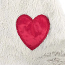 Stuffed animal blankie bear in soft grey fabric with a prominent red heart patch stitched on its side.